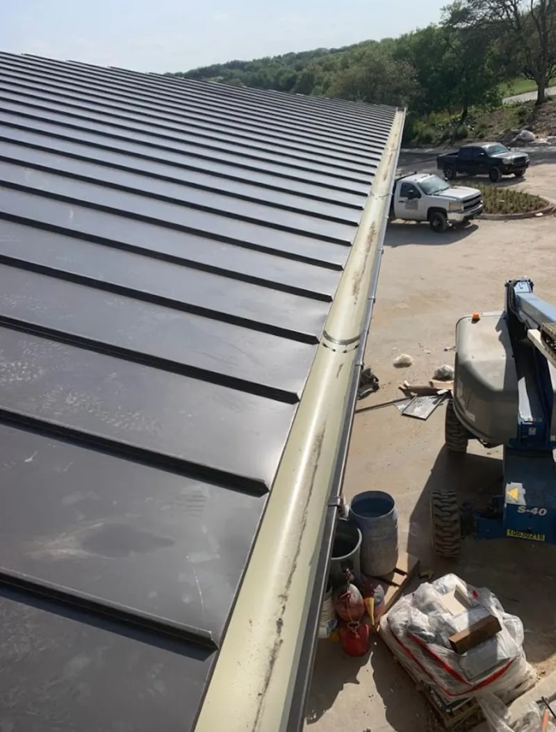 Standing seam panel and gutter detail on a metal roofing jobsite in Colchester